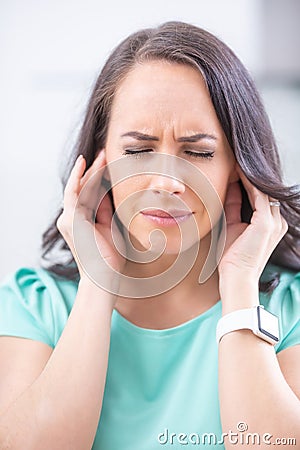 Young woman have headache migraine stress or tinnitus - noise whistling in her ears Stock Photo