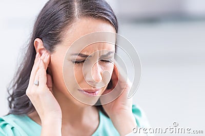 Young woman have headache migraine stress or tinnitus - noise whistling in her ears Stock Photo