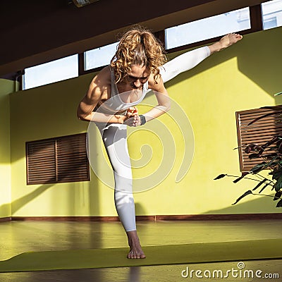 Young Woman, Healthy Lifestyle and Yoga Practitioner, Performs Adhomukha Uthitahasta Padangushthasana Exercise 2 Stock Photo