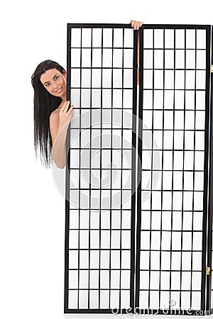 Young woman hiding behind panel Stock Photo