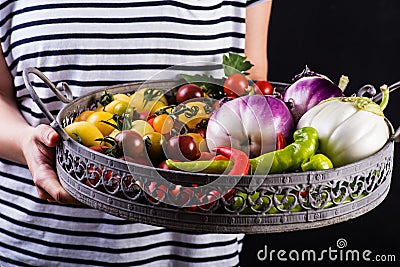 Young woman holding a basket full of veggies Stock Photo