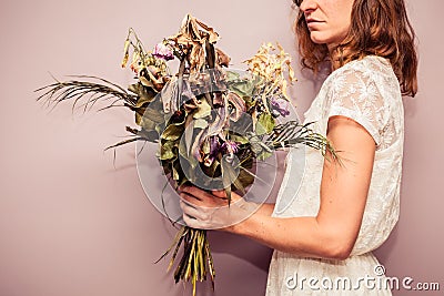 http://thumbs.dreamstime.com/x/young-woman-holding-bouquet-dead-flowers-43925949.jpg