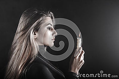 Young woman holding a candle in a smoke Stock Photo