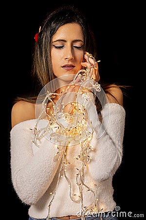 Young woman holding Christmas's string lights Stock Photo