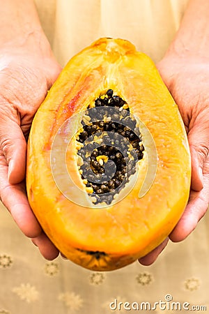 Young woman holding in hands half of ripe juicy papaya, close up Stock Photo