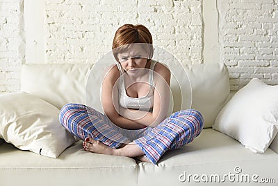 Young woman holding hurting belly suffering stomach cramp period pain Stock Photo