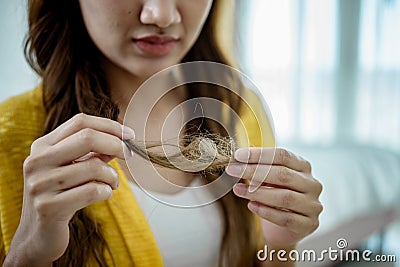 Young woman holding and looking her demaged hair Stock Photo