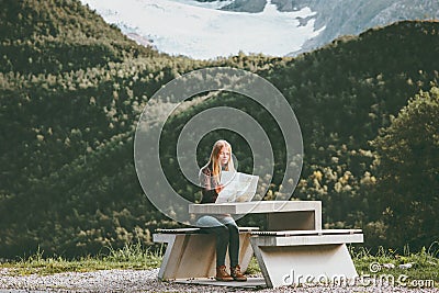 Young Woman holding map planning journey route in Norway sitting at the table Travel Lifestyle concept adventure vacations Stock Photo