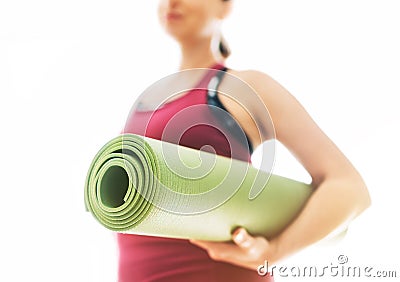 Young Woman holding rolled gymnastic yoga rubber mat on the white background light starting morning yoga exercises. Active people Stock Photo