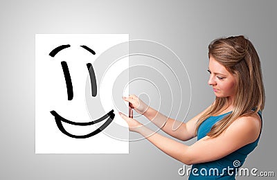 Young woman holding smiley face drawing Stock Photo