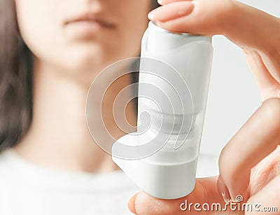 Woman holding spray inhaler against asthma attack. Stock Photo