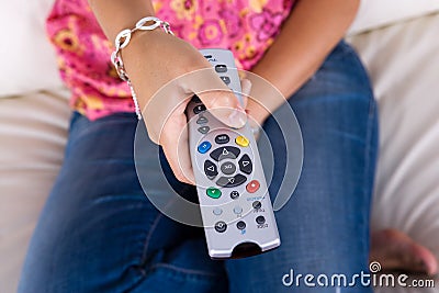 Young woman holding the television remote control Stock Photo