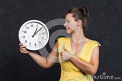 A young woman is holding a watch. Time concept. A girl with a clock in her hands. Keep track of time Stock Photo