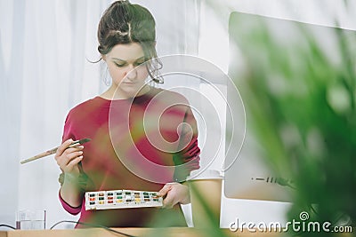 Young woman holding watercolor pallet Stock Photo