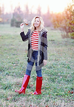 Young woman holding yellowed leaf on the autumn field Stock Photo