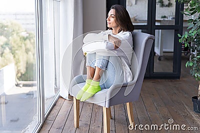 A young woman at home in a cozy white hoodie Stock Photo