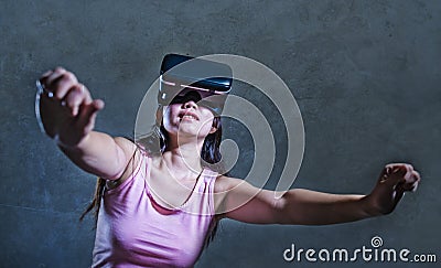 Young woman at home sofa couch playing video game using VR virtual reality goggles watching in 3 dimension enjoying curious having Stock Photo