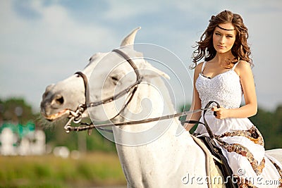 Young woman on a horse. Horseback rider, woman riding horse on b Stock Photo