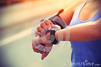 Young woman jogger ready to run set and looking at sports smart watch Stock Photo