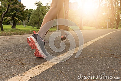 young woman Jogging in the park in the morning under warm sunlight Stock Photo
