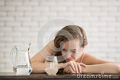 Young woman in joyful postures with jug and glass of drinking water Stock Photo