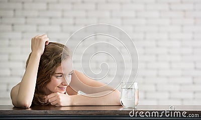 Young woman in joyful postures with jug and glass of drinking water Stock Photo