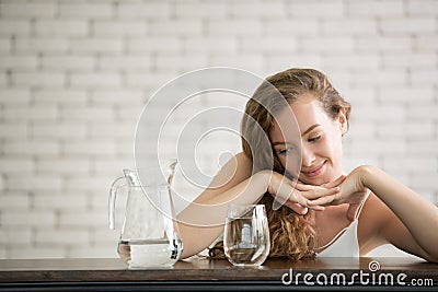 Young woman in joyful postures with jug and glass of drinking water Stock Photo