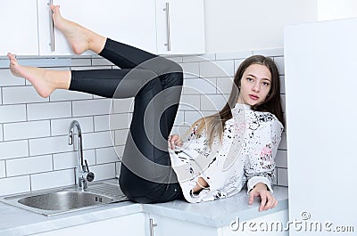 Young woman in kitchen with black leggins Stock Photo