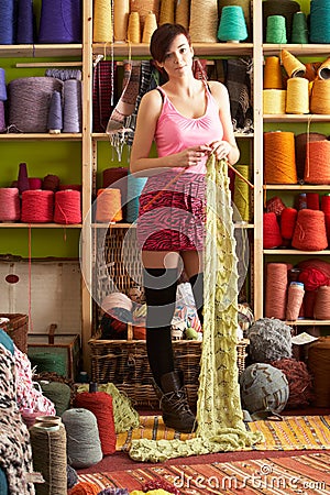 Young Woman Knitting Scarf Standing Stock Photo