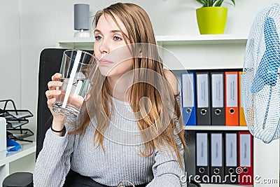 Young woman is knocked off heat in the office Stock Photo