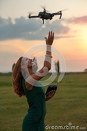 Young woman landing a drone in her hand Stock Photo