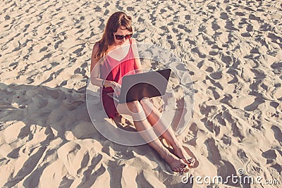 Young woman with laptop computer on the beach. Downshifting and Stock Photo