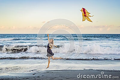 A young woman launches a kite on the beach. Dream, aspirations, future plans Stock Photo