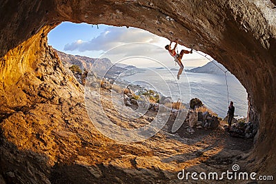 Young woman lead climbing in cave Stock Photo