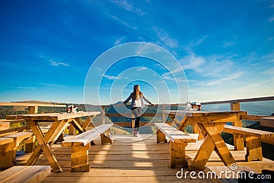 Young woman with long hair have rest in open air cafe on top of mountains and enjoy view Stock Photo