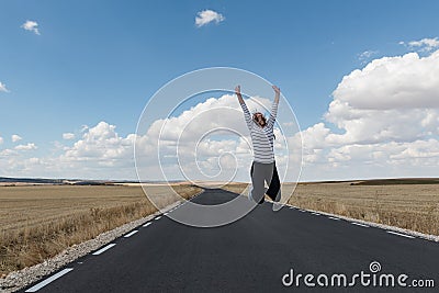 Young woman jumping on the road on nowhere Stock Photo