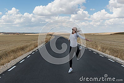 Young woman jumping on the road on nowhere Stock Photo