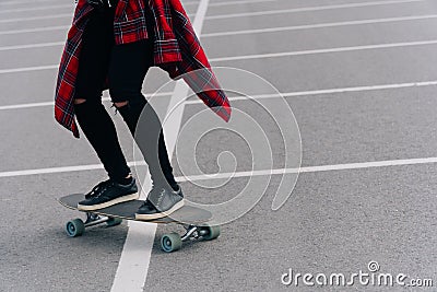 Young woman with longboard on asphalt does a trick on a city street Stock Photo