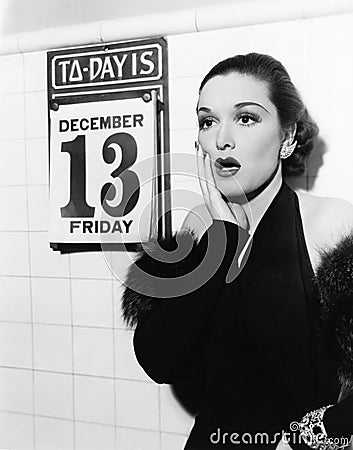 Young woman looking shocked after seeing Friday the 13th on a calendar Stock Photo