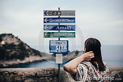 Young woman looking at sign table for direction.Wman on vacation in Italian coast.South cosat of Italy, Amalfi and Positano sights Stock Photo