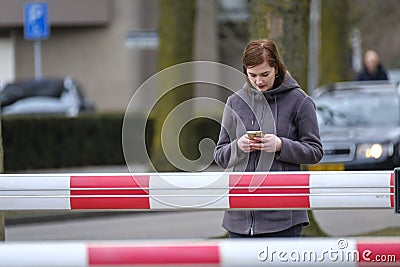 Young woman looks on her mobile at a railroad crossing Stock Photo