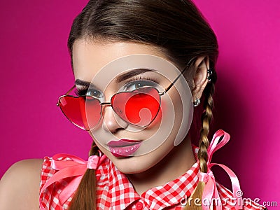 Young woman looks over heart shaped glasses Stock Photo