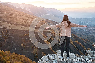Young woman with loose flowing hair stands on grey hilltop Stock Photo
