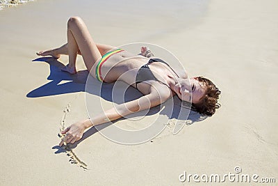 Young woman lounging at the beach Stock Photo