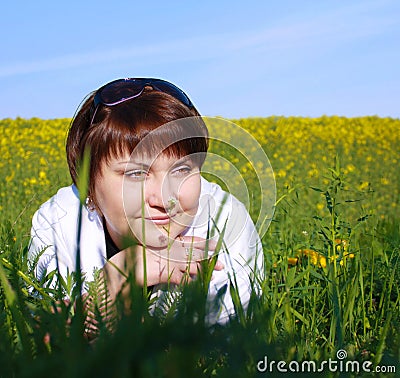 The young woman is lying on a grass on the field Stock Photo
