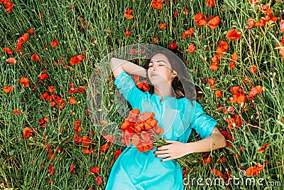 Young woman lying on summer poppy meadow. Stock Photo