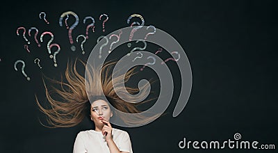 Young woman lying thinking with question mark written with chalk on school blackboard above head, brainstorming concept, girl Stock Photo