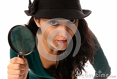 Young woman with magnifier glass and hat looking Stock Photo