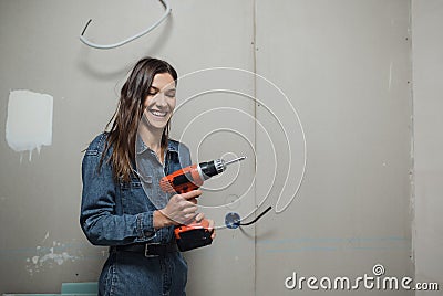 A young woman makes apartment renovations on her own. Apartment renovation concept. Strong independent woman Stock Photo