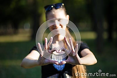 Young woman makes hands in shape of love heart Stock Photo